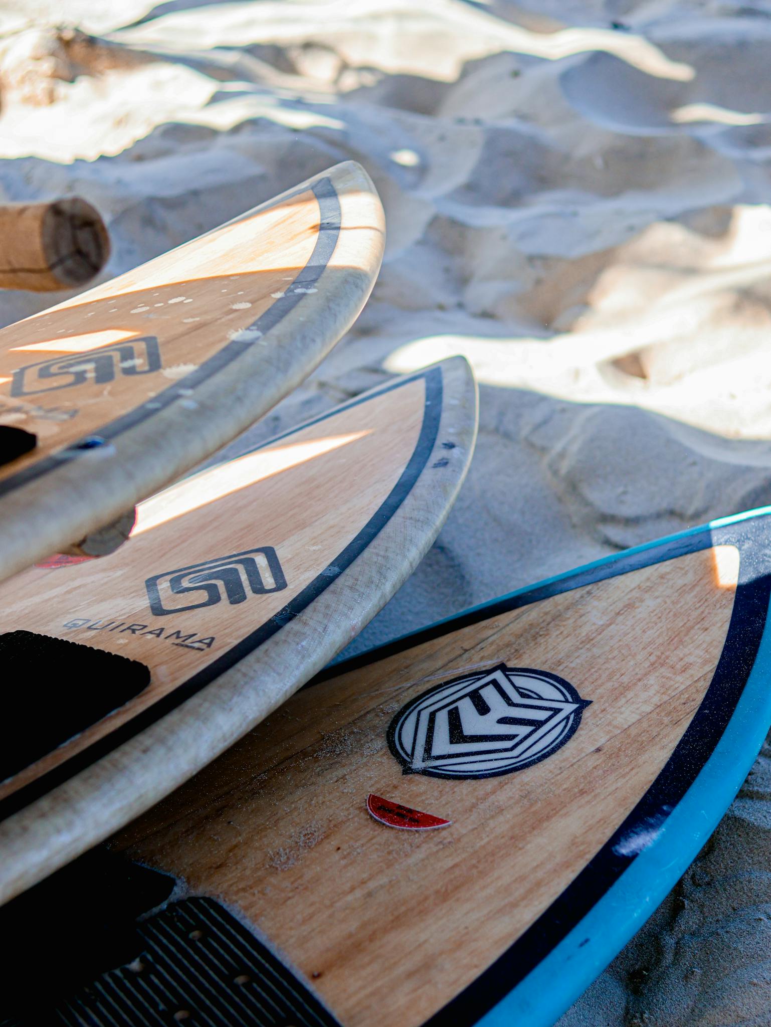 Surfboards lying on a sandy beach, perfect for summer surfing adventures.