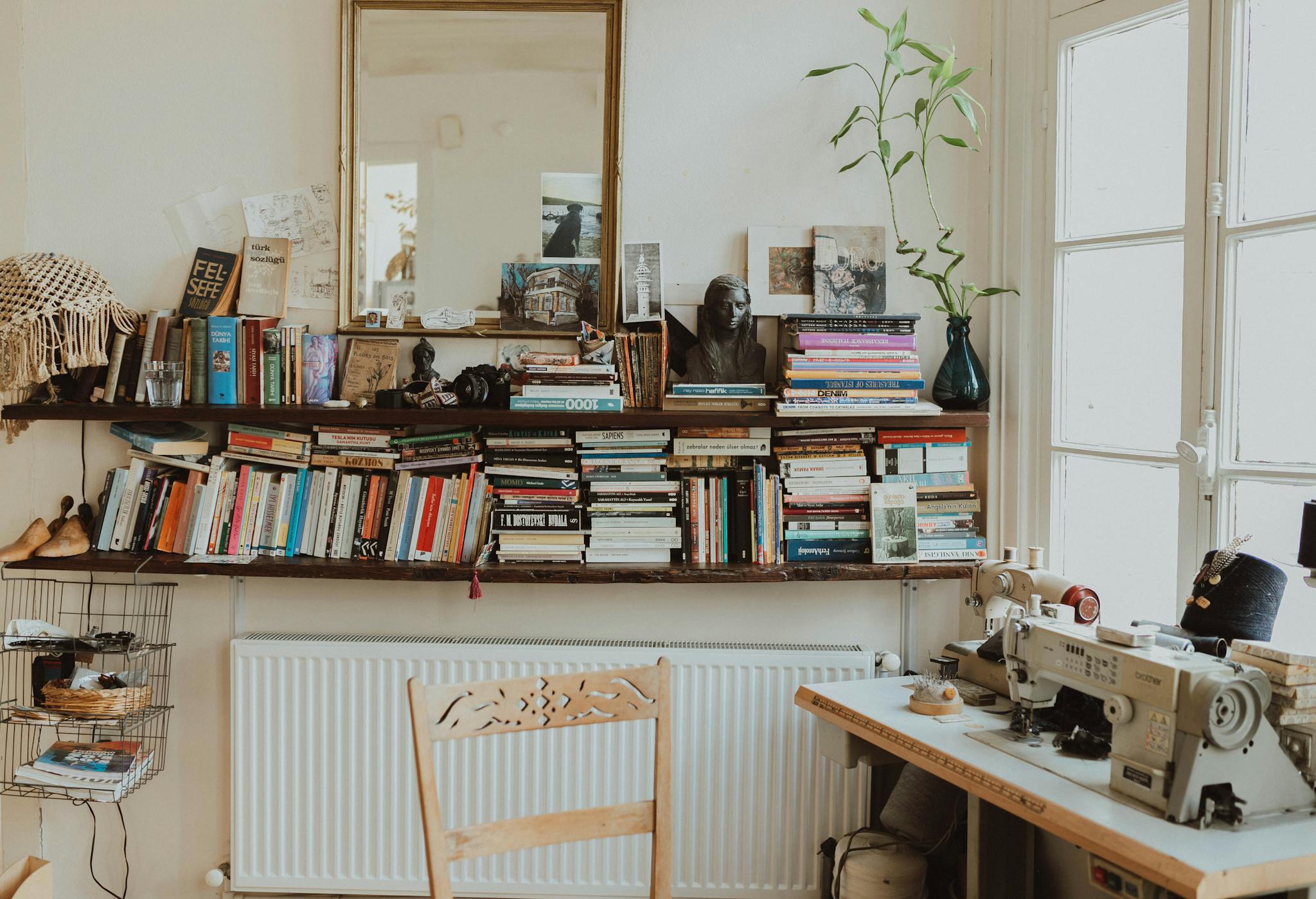Warm and inviting home office featuring a sewing machine, bookshelves, and vintage decor. Perfect for creative inspiration.
