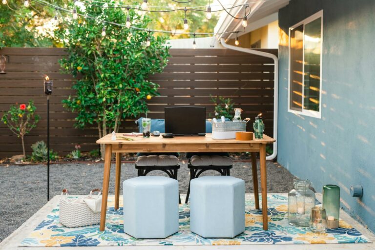 A cozy outdoor home office setup with string lights in a sunny San Diego backyard.